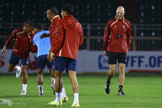 HLV Matt Ross và cầu thủ Nepal tập luyện trong mưa trên sân Thống Nhất, TP HCM tối 13/10 để chuẩn bị cho trận tiếp Việt Nam ở vòng loại cuối Asian Cup 2027. Ảnh: Đức Đồng